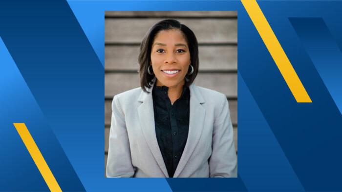 An image of TAMUC alum Dr. Terri D. Osborne wearing a gray business suit displayed over a blue and gold background.